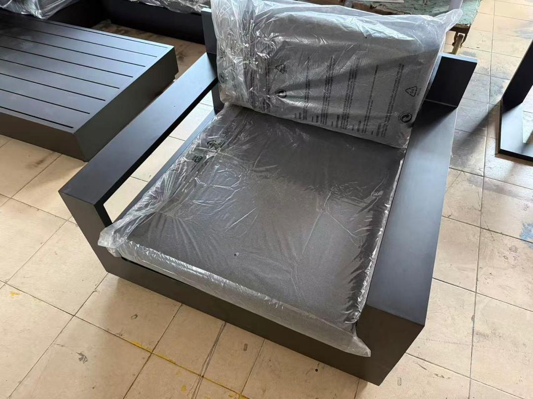 Custom black outdoor armchair with cushion wrapped for delivery